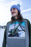 Person wearing a gray hoodie with a graphic design of avalanche dogs and mountain landscape.