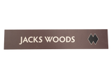Rectangular brown sign with 'JACKS WOODS' text 