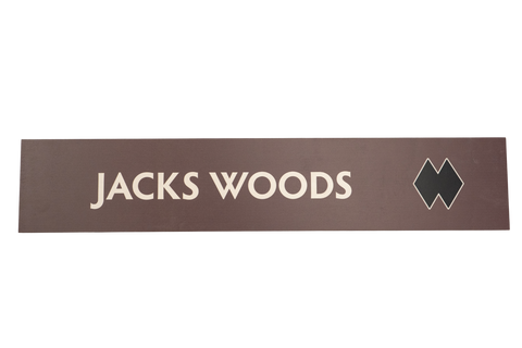 Rectangular brown sign with 'JACKS WOODS' text 