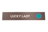 Rectangular sign with 'LUCKY LADY' text and a blue circle on a brown background