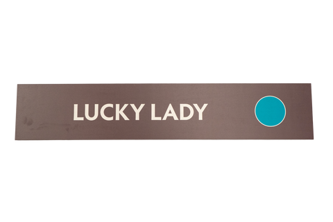 Rectangular sign with 'LUCKY LADY' text and a blue circle on a brown background