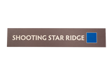 Rectangular brown sign with 'SHOOTING STAR RIDGE' text and a blue square icon