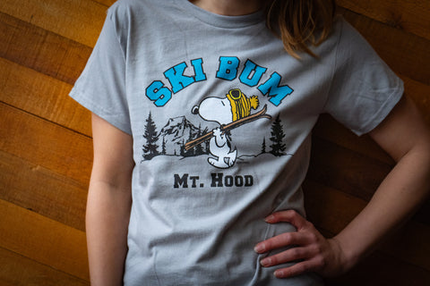 Person wearing a gray t-shirt with a Snoopy graphic and 'Ski Bum Mt. Hood' text.