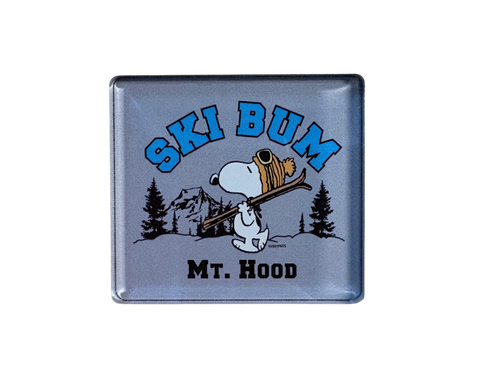 Ski bum-themed magnet with Snoopy on a grey background