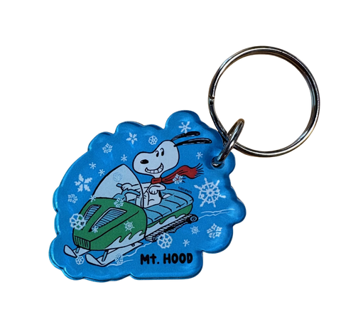 Keychain with cartoon character on a snowmobile against a blue background