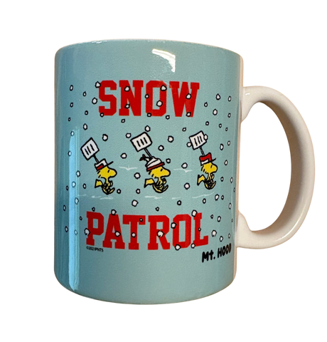 Mug with cartoon design and text 'Snow Patrol' on a light aqua background