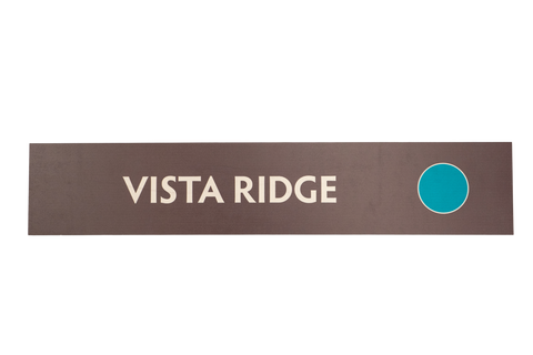 Rectangular brown sign with 'Vista Ridge' text and a green circle icon